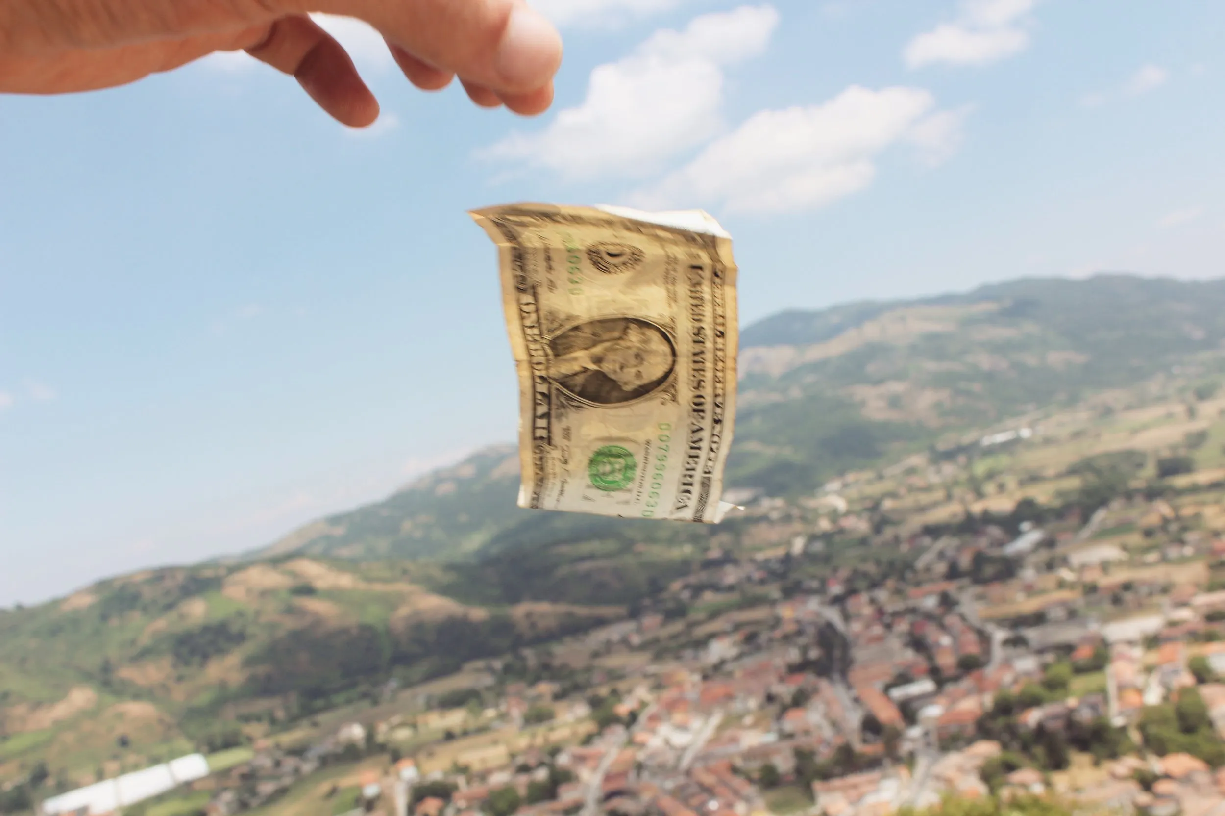 A crumpled ten dollar bill let go into the air.